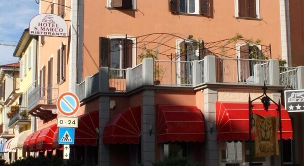 A hotel with a sign reading "HOTEL S. MARCO RESTORANTE" and a no parking sign.