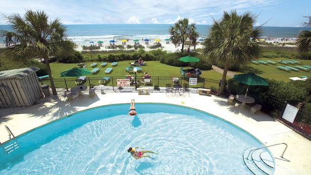 A swimming pool with a view of the beach and ocean. - Palms Resort (Myrtle Beach)