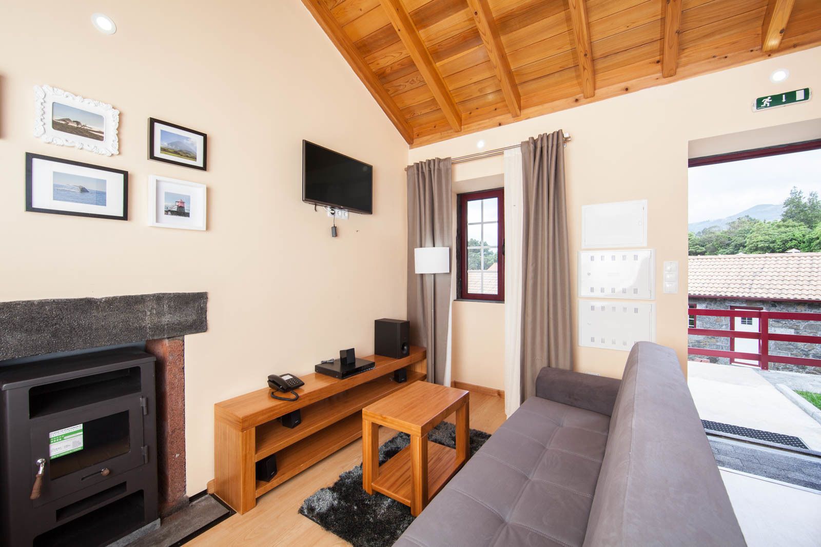 A cozy room with a fireplace, a TV, a sofa, and a wooden table.