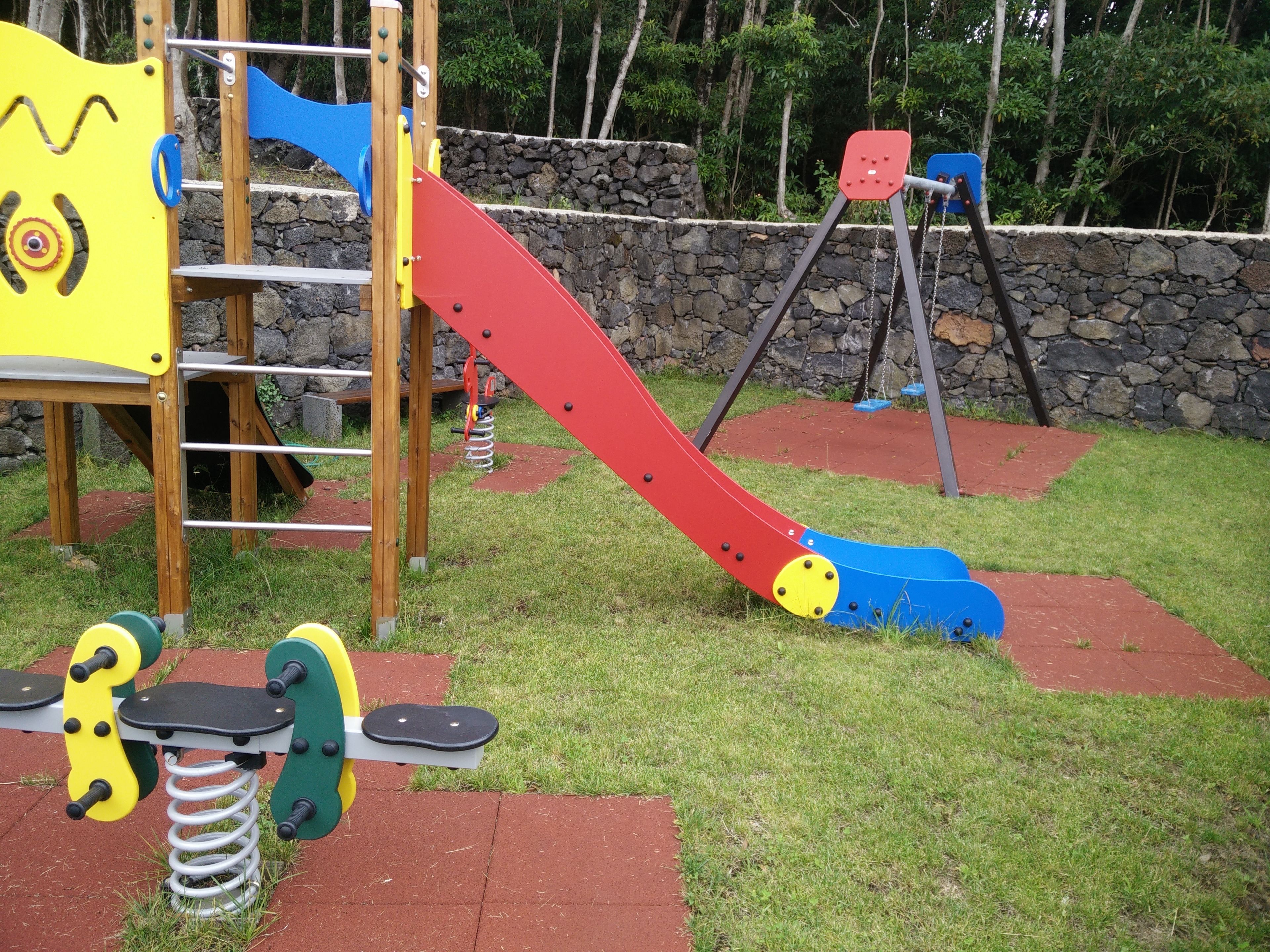 A playground with a slide, climbing structures, and swings.