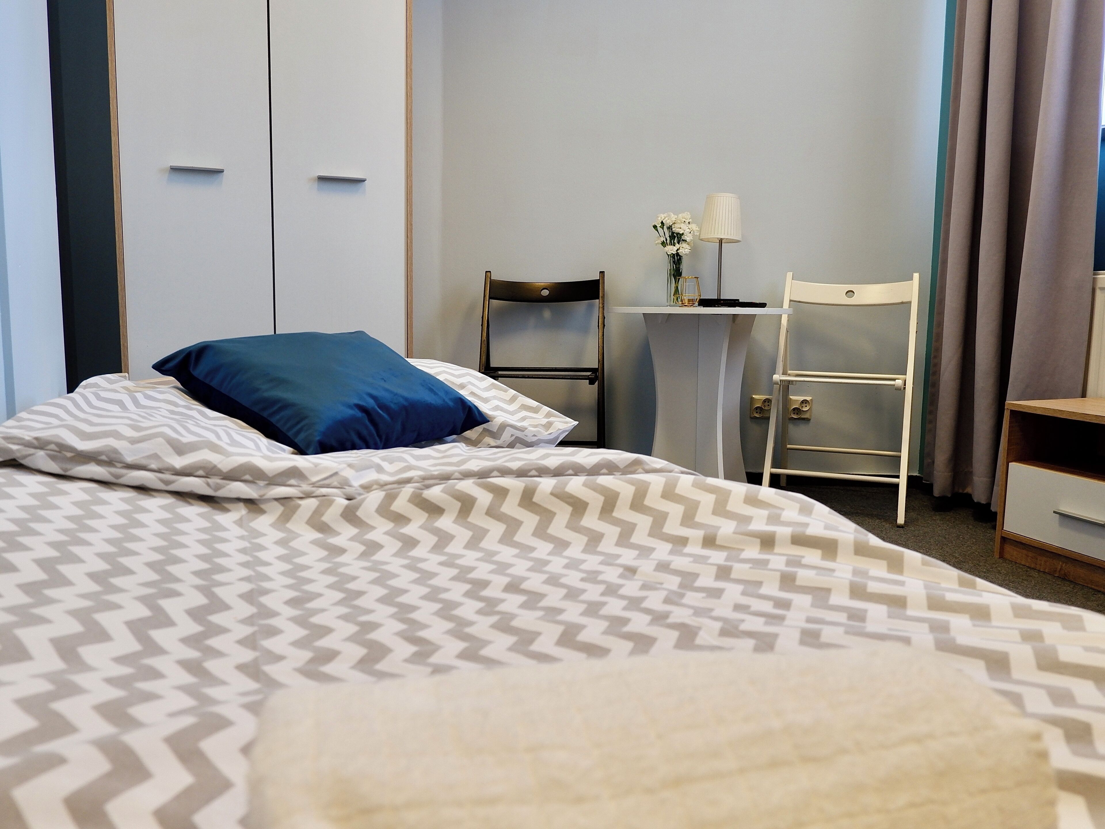 Ein Hotelzimmer mit Bett, Schreibtisch, Stuhl und Kleiderschrank.