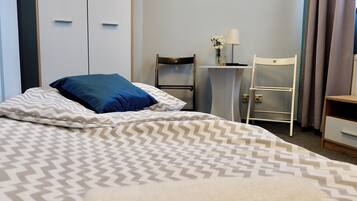 Een hotelkamer met een bed, een bureau, een stoel en een kledingkast.