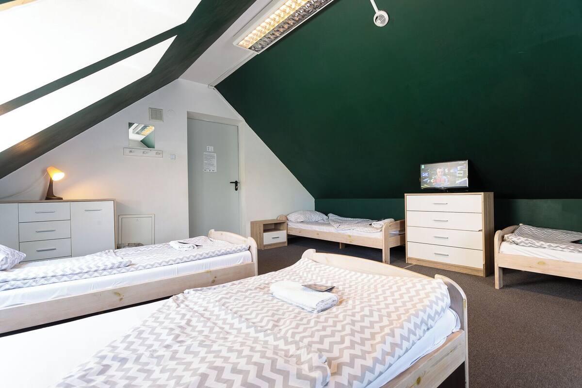 Un dormitorio con dos camas, un escritorio, una silla y un televisor.