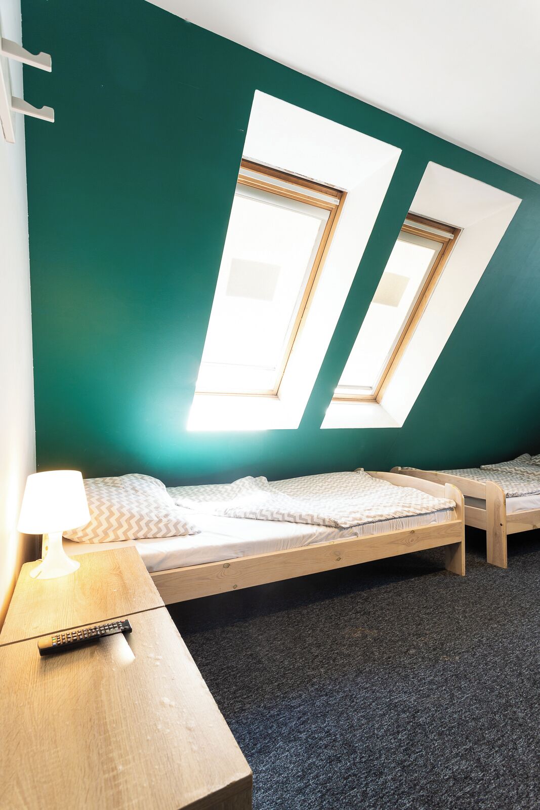 Een kamer met twee bedden, een bureau en een lamp.