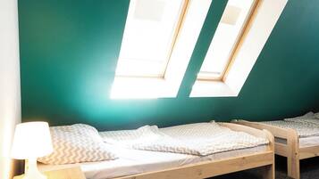 Een kamer met twee bedden, een bureau en een lamp.