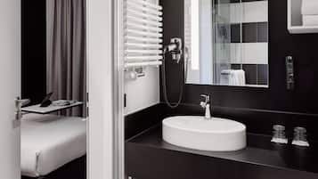 Une salle de bain moderne avec un lavabo blanc, un grand miroir et un porte-serviettes.