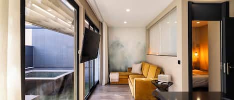 A modern interior with a sofa, a table, and a bed.