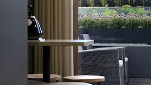 A modern indoor seating area with a view of a garden through a glass wall.