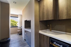A modern kitchen with a white countertop, a gold faucet, and a Marshall amplifier. - Charm Flats (Lisbon)