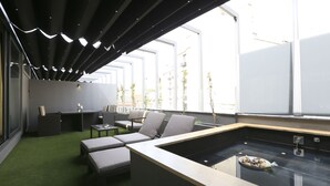 A modern lounge area with a pool table, seating, and a view of the city.