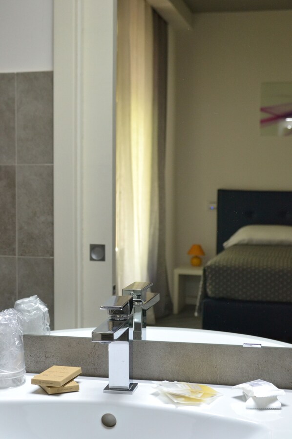 A bathroom with a sink, mirror, and toiletries. - Hotel Panorama (Chianciano Terme)