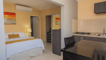 Una habitación de hotel con cama, escritorio y kitchenette.