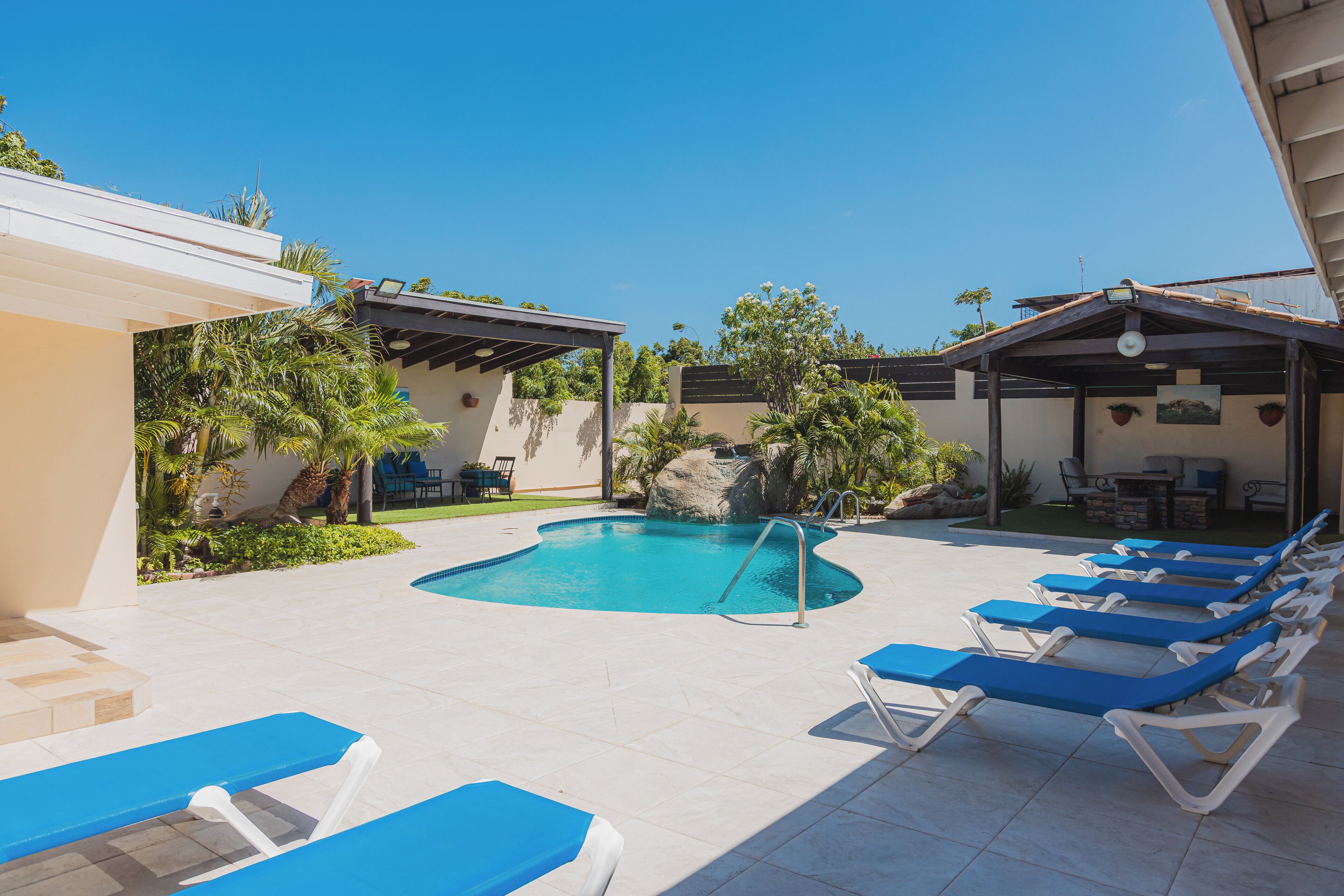 A pool area with lounge chairs and a small pool.