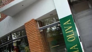 Un edificio con un letrero verde que dice "THIA OLIVA".