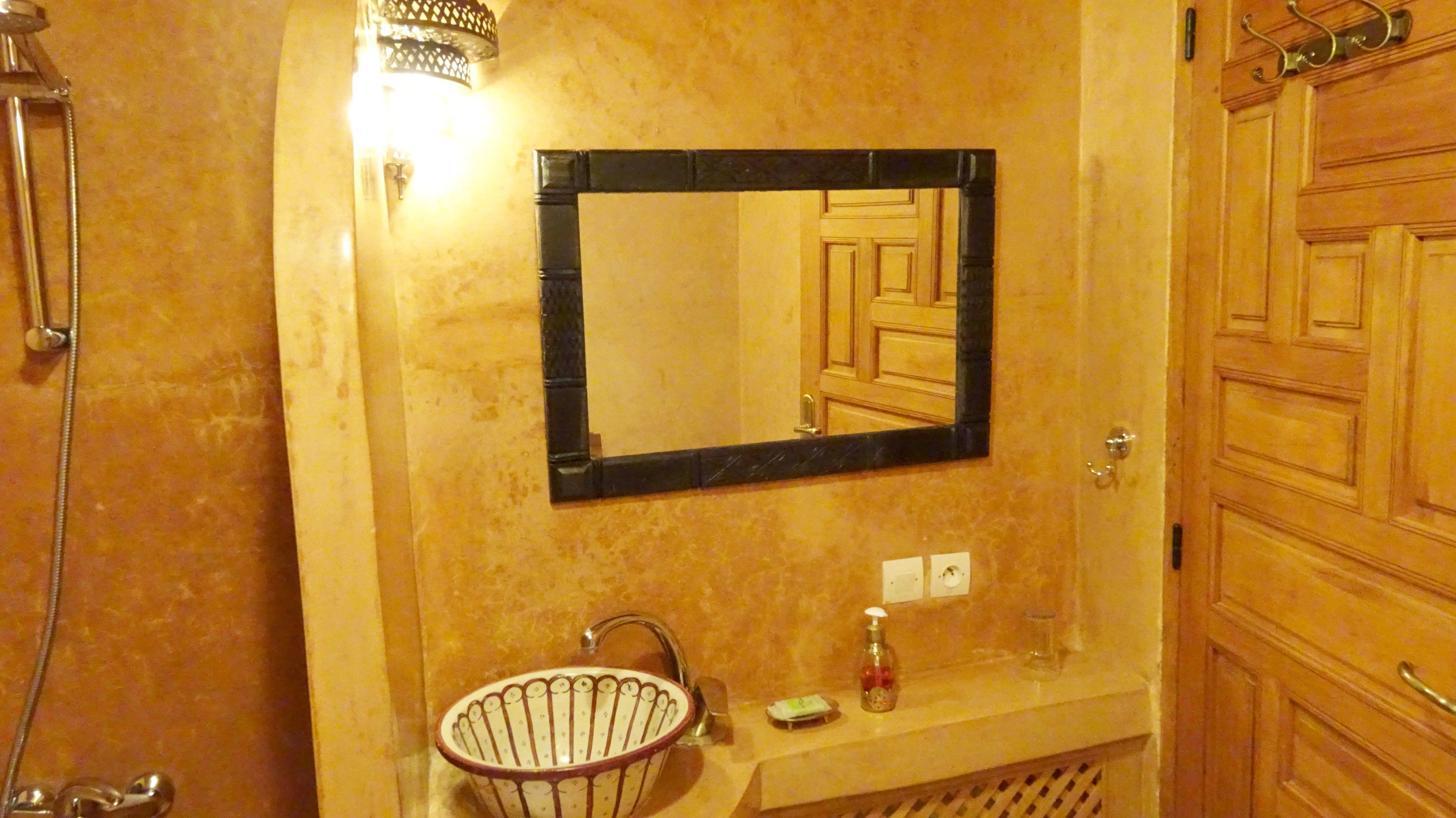 Un baño con lavamanos, espejo y ducha.