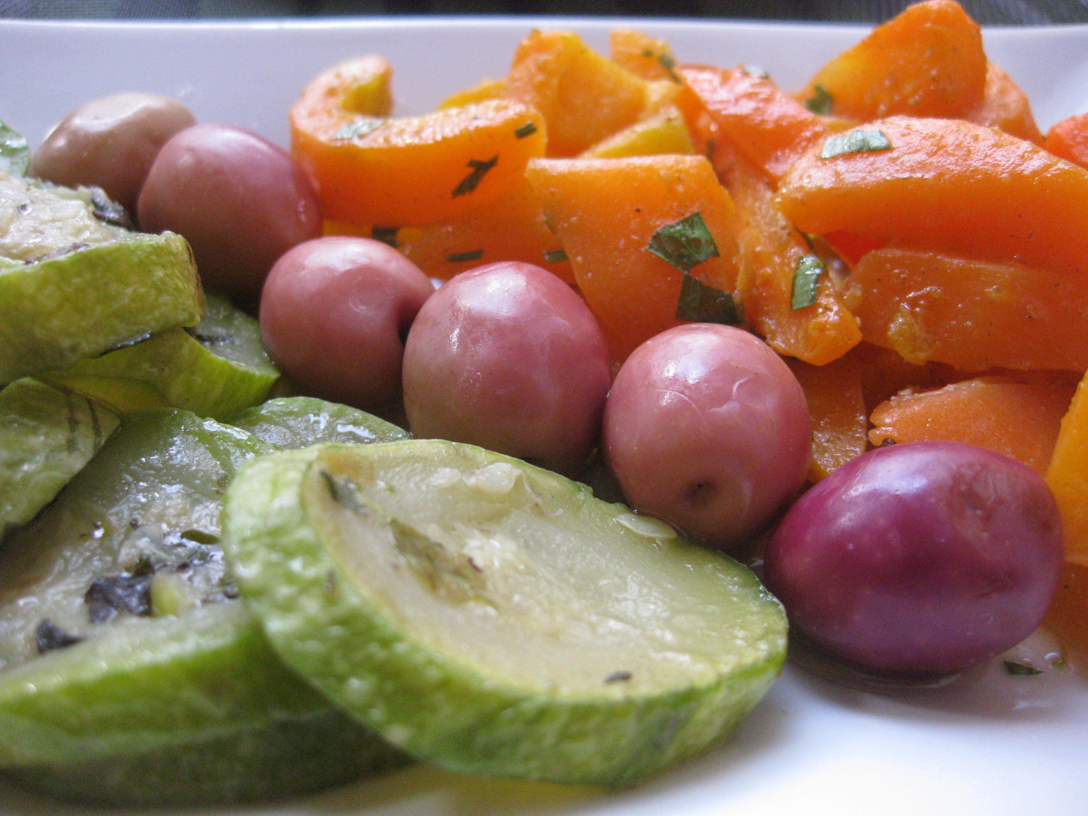 Un plato de frutas cortadas, como manzanas, uvas y quizá cítricos.