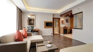 Une chambre d’hôtel avec un canapé, un bureau, un lit et une petite table sur laquelle se trouvent une assiette et un bol.