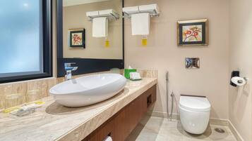 A modern bathroom with a large sink, a toilet, and a shower.