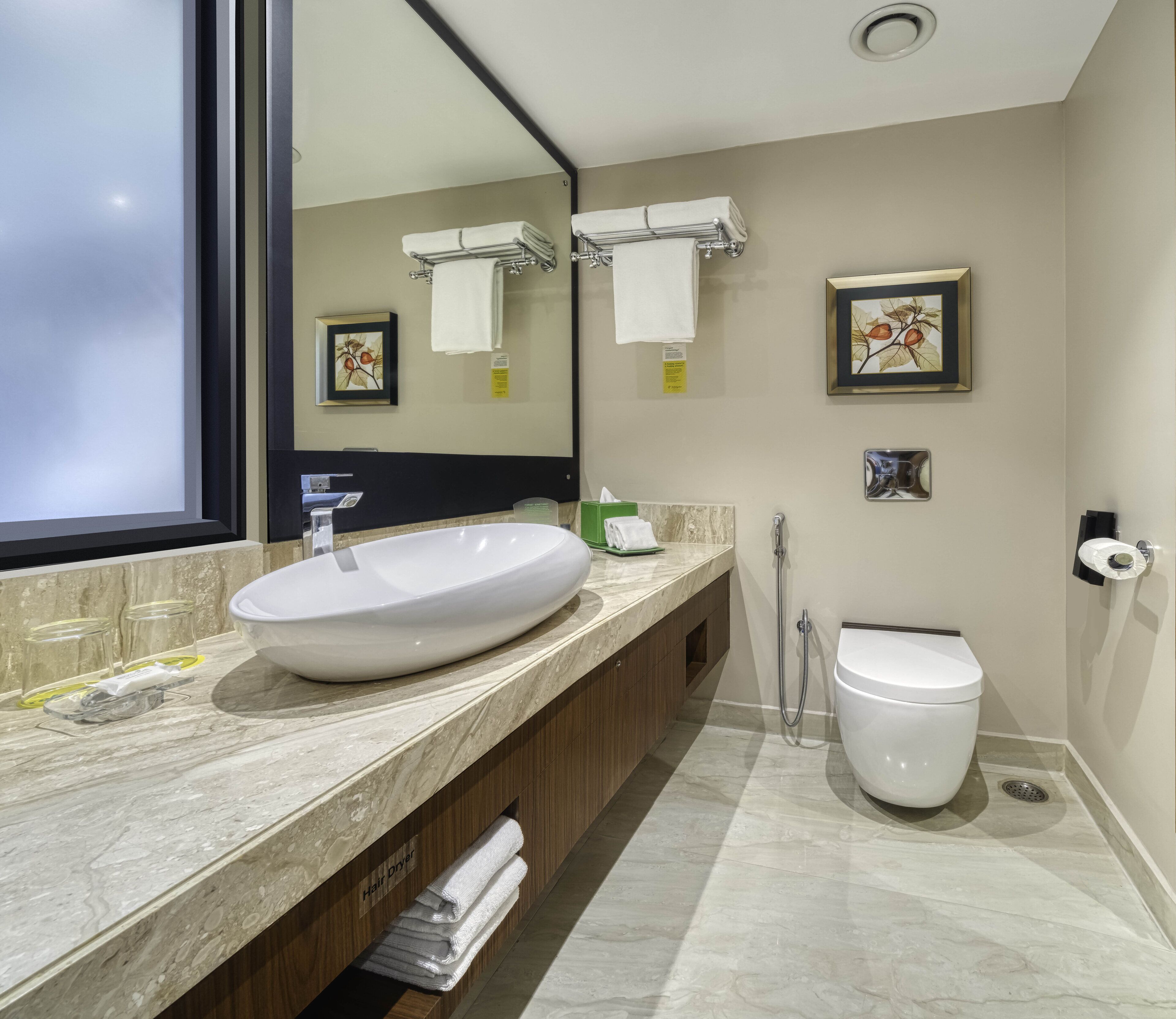 A modern bathroom with a large oval sink, a toilet, and a shower.