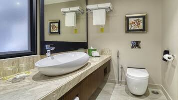 Un baño moderno con un lavamanos ovalado grande, un inodoro y una ducha.