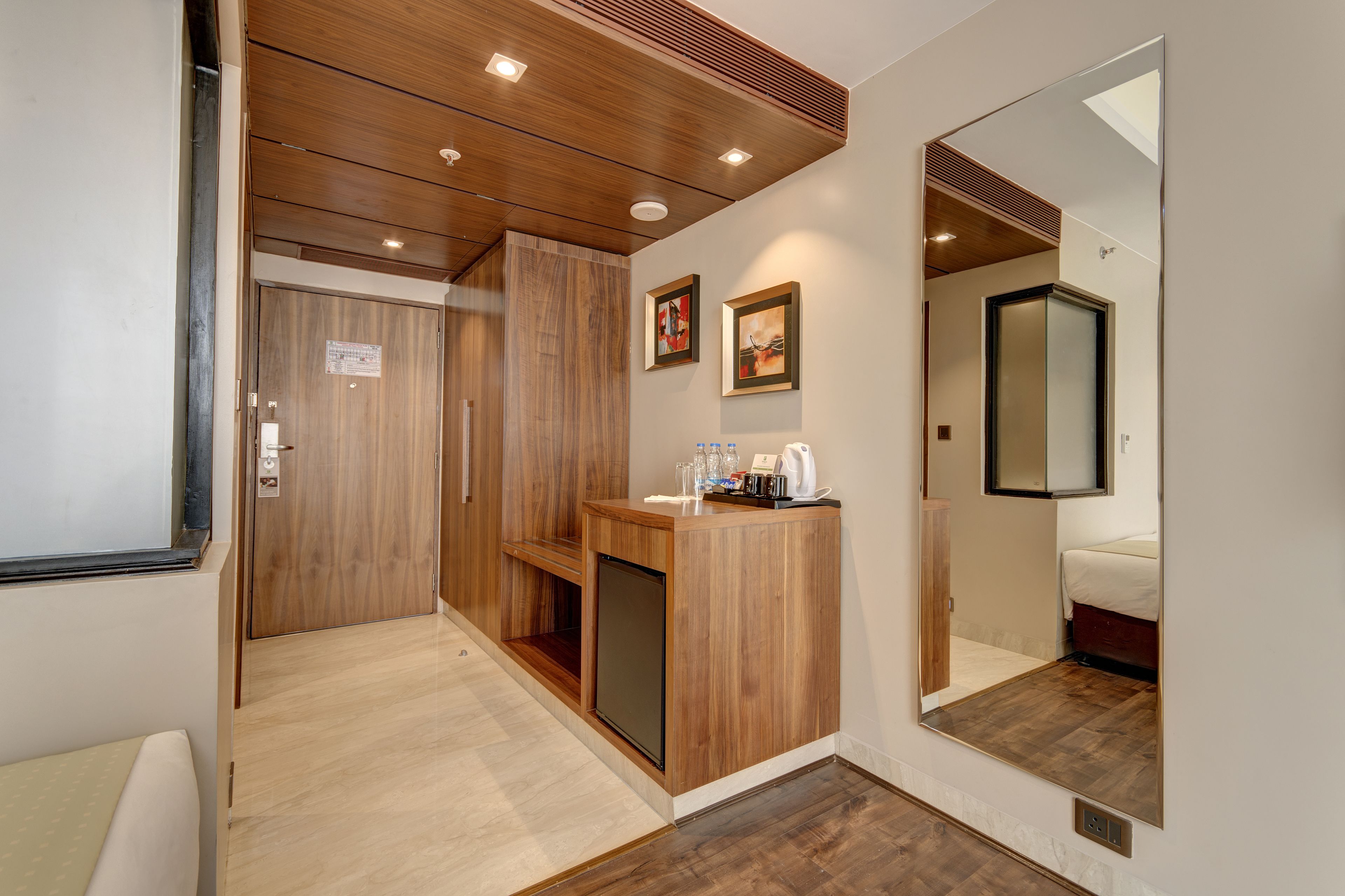 Une chambre d’hôtel avec un comptoir d’accueil en bois, un miroir et un lit.