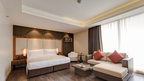 Una habitación de hotel moderna con una cama grande, un sofá, una mesa de centro y una silla.