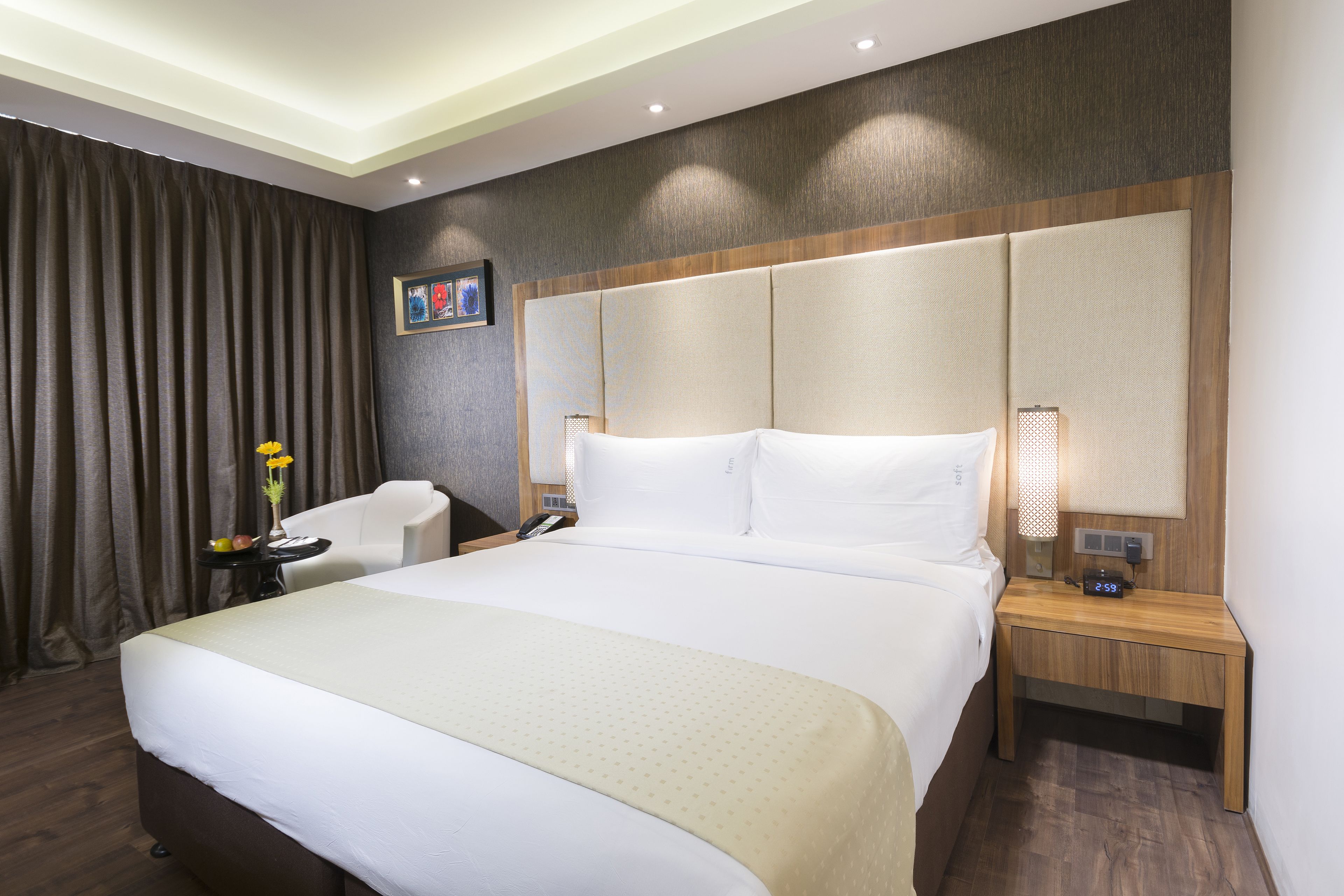 Une chambre d’hôtel avec un grand lit, une table de chevet, une chaise et un bureau.
