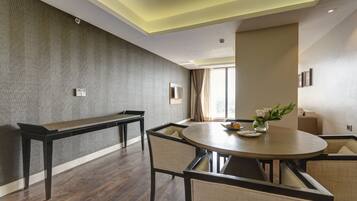A modern dining area with a round table, cushioned chairs, and a bench.