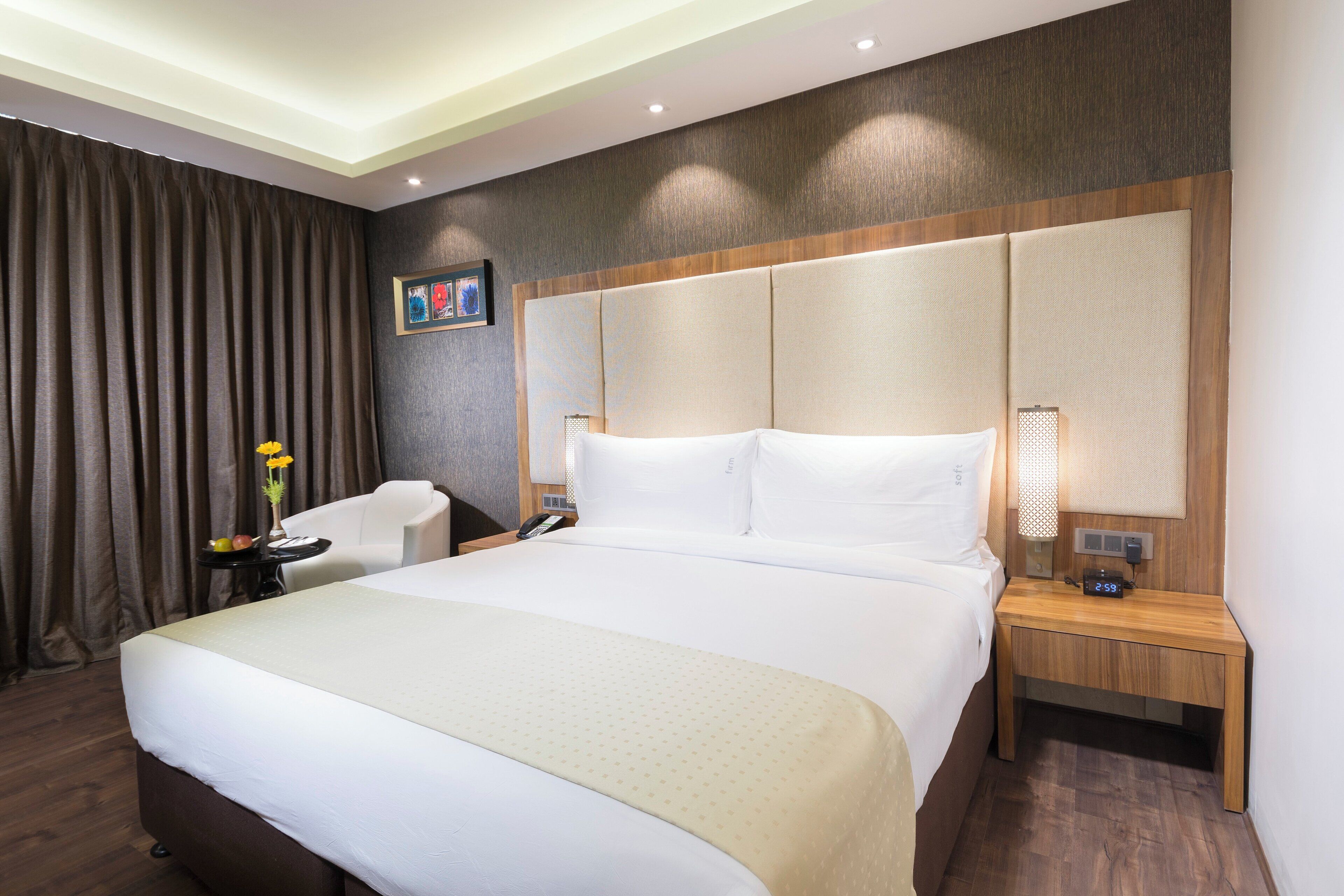 A hotel room with a large bed, bedside tables, a desk, and a chair.