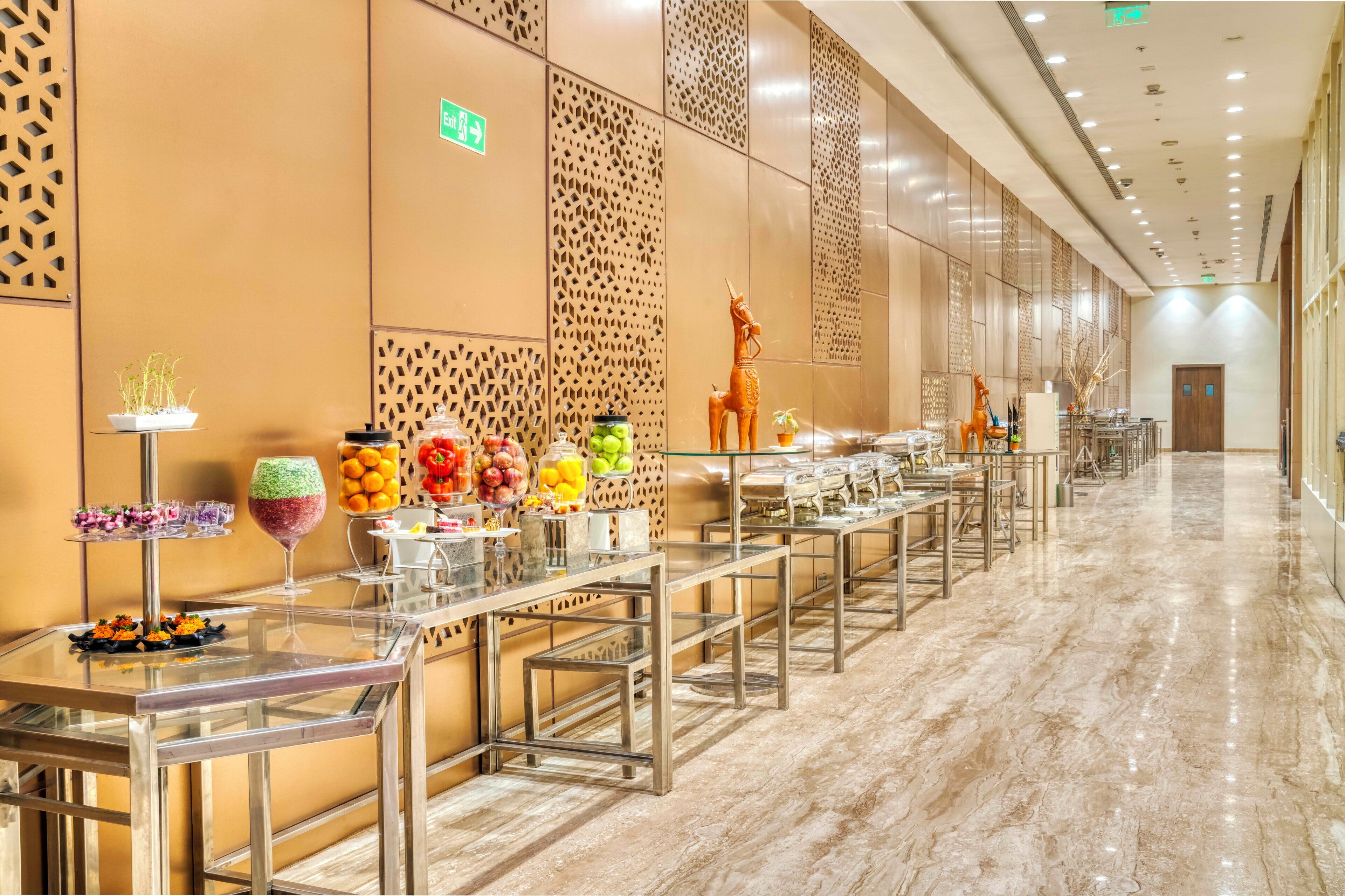 A hotel corridor with a buffet setup, including various food and drink stations.