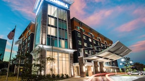A multi-story hotel with a prominent 'Cambria' sign, large windows, and a covered entrance. - Cambria Hotel LAX (El Segundo)