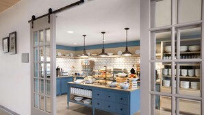 A kitchen with a blue island, white cabinets, and hanging pendant lights. - Country Inn & Suites by Radisson, Charlottesville-UVA, VA (Charlottesville)