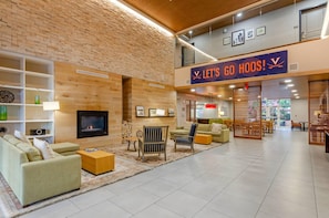 A spacious lobby with a fireplace, seating area, and a sign that reads 'LET'S GO HOOS!' - Country Inn & Suites by Radisson, Charlottesville-UVA, VA (Charlottesville)