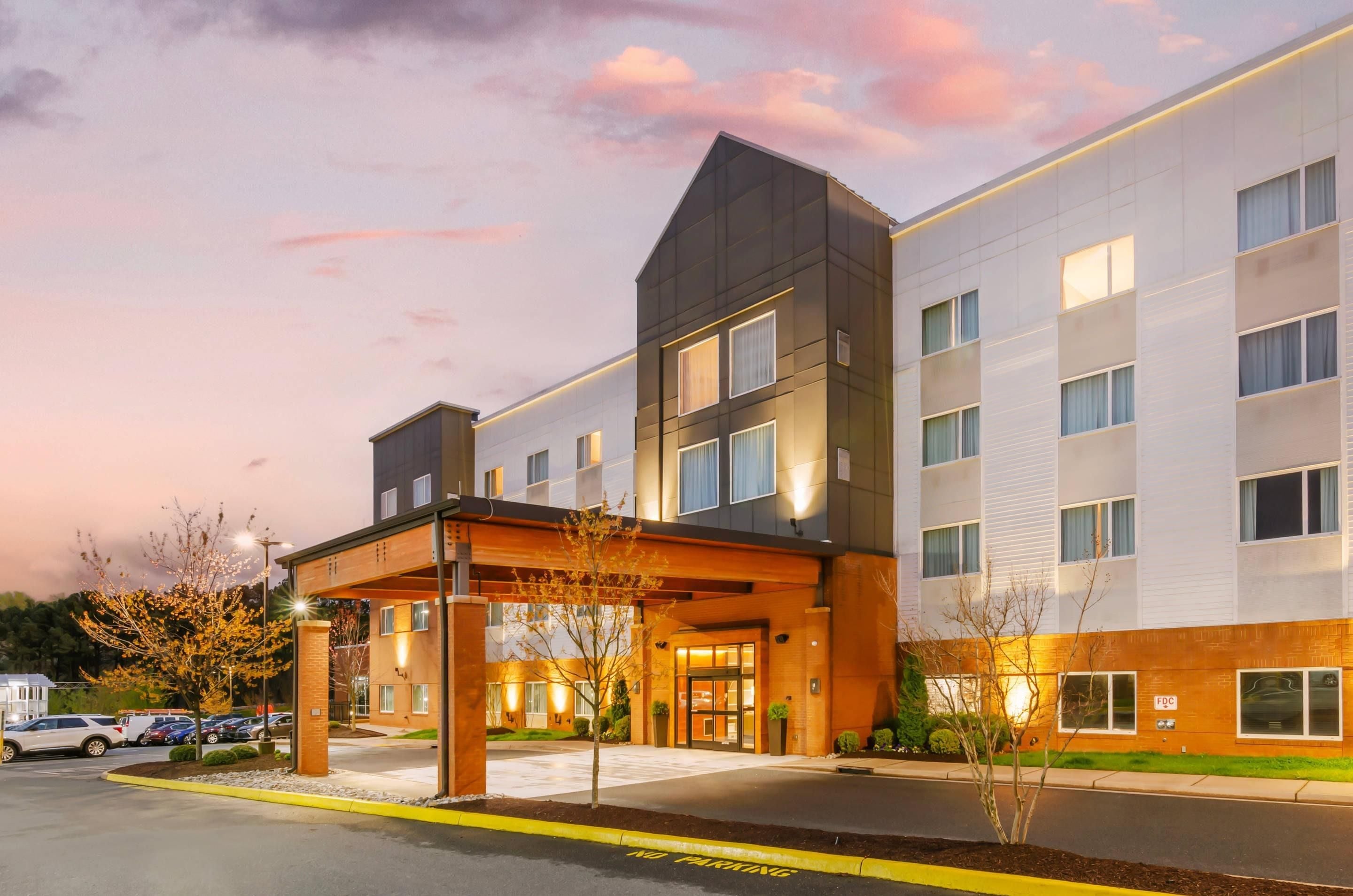 A multi-story hotel with a covered entrance and a parking lot.
