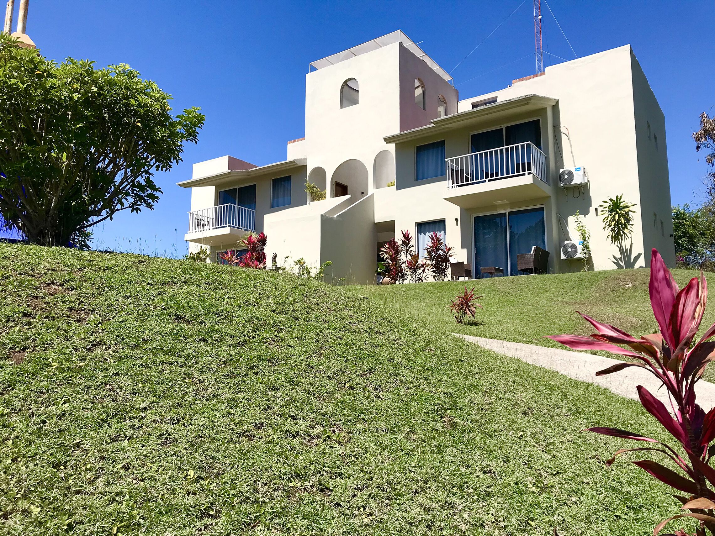 Un bâtiment moderne à deux étages, doté d’un toit plat, de grandes fenêtres et d’un balcon.