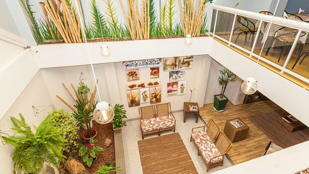 Un interior espacioso y luminoso, con techo alto, suelo de madera y diferentes opciones de asientos.