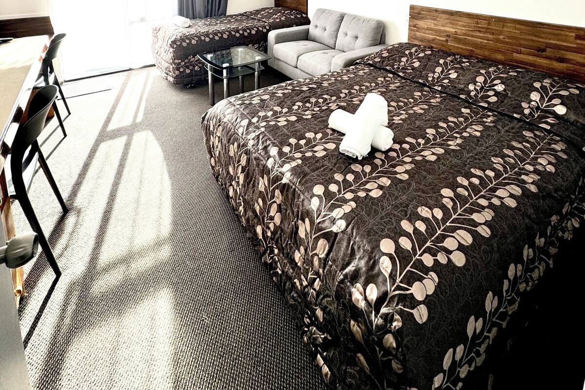 Une chambre d’hôtel avec un grand lit, un canapé, une petite table et une chaise.