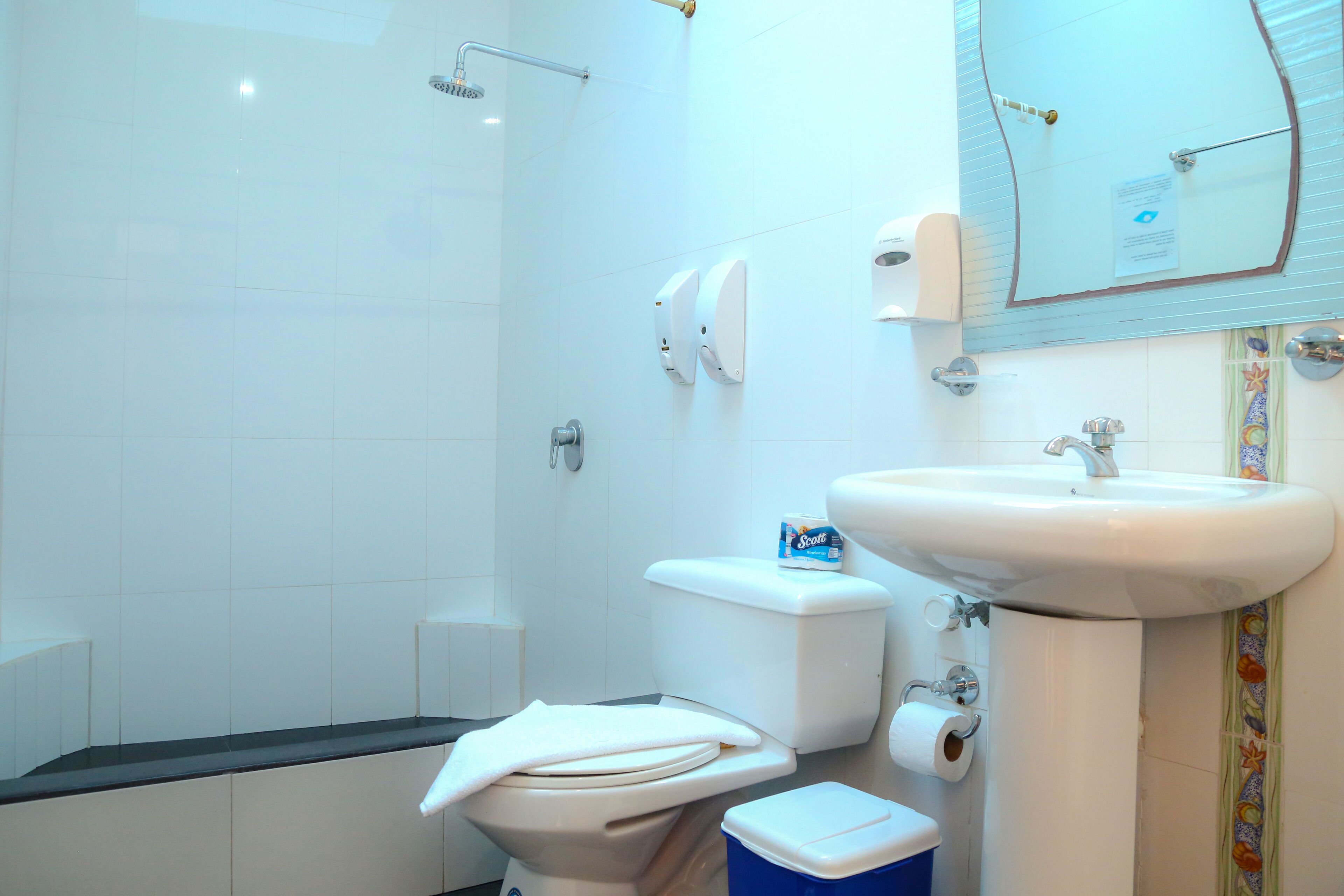 A bathroom with a toilet, bidet, sink, and shower.