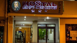 Un edificio de dos pisos con un letrero que dice "HOSTAL Sir Francis Drake".