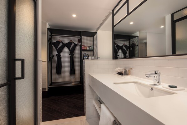 A modern bathroom with a large mirror, white sink, and dark wooden flooring. - Glad Live Gangnam (Seoul)