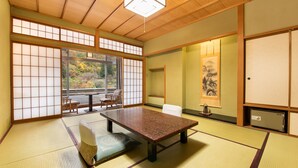 Une pièce de style japonais traditionnel, avec un sol recouvert de tatamis, une table basse et des portes coulissantes.