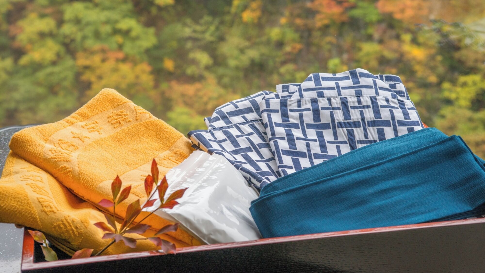 A box containing folded towels in yellow, white, and blue.
