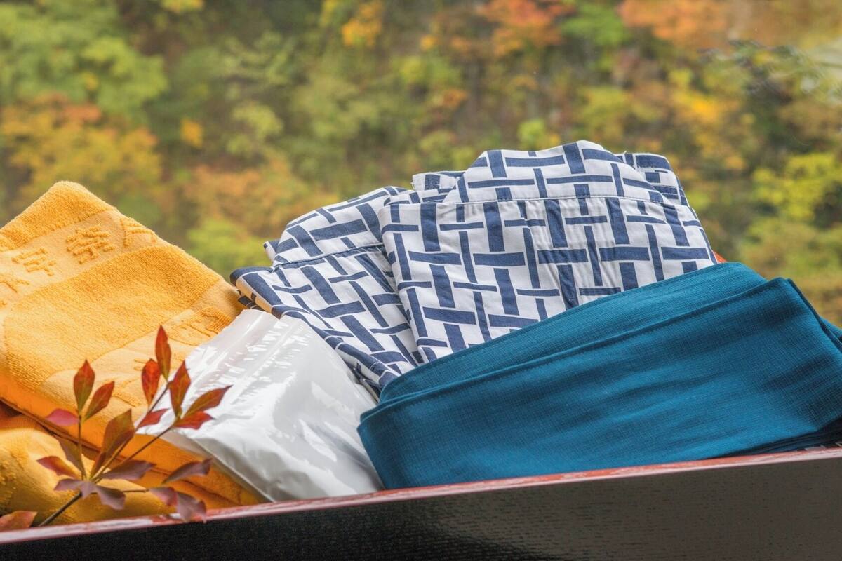 A box containing folded towels in yellow, white, and blue.