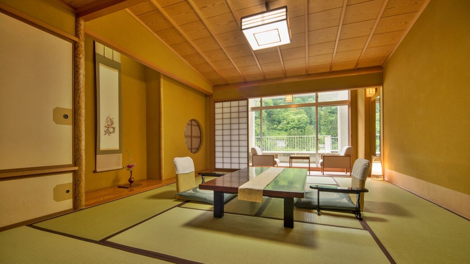 A tatami mat room with a low table and chairs, a shoji screen, and a view of greenery outside.