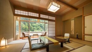 A traditional Japanese-style room with tatami flooring, a low table, and sliding doors.