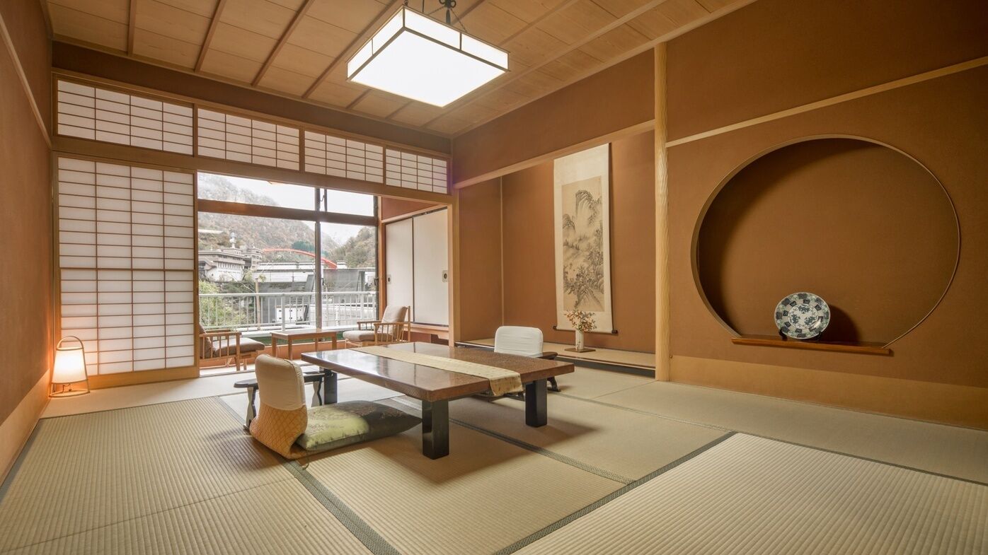 A traditional Japanese room with tatami flooring, a low table, and sliding doors.