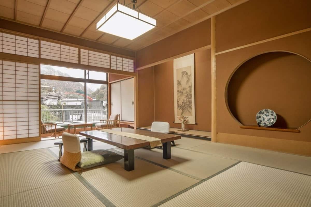 A traditional Japanese room with tatami flooring, a low table, and sliding doors.