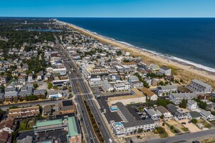 An aerial view of a coastal town with a beach, roads, and buildings.