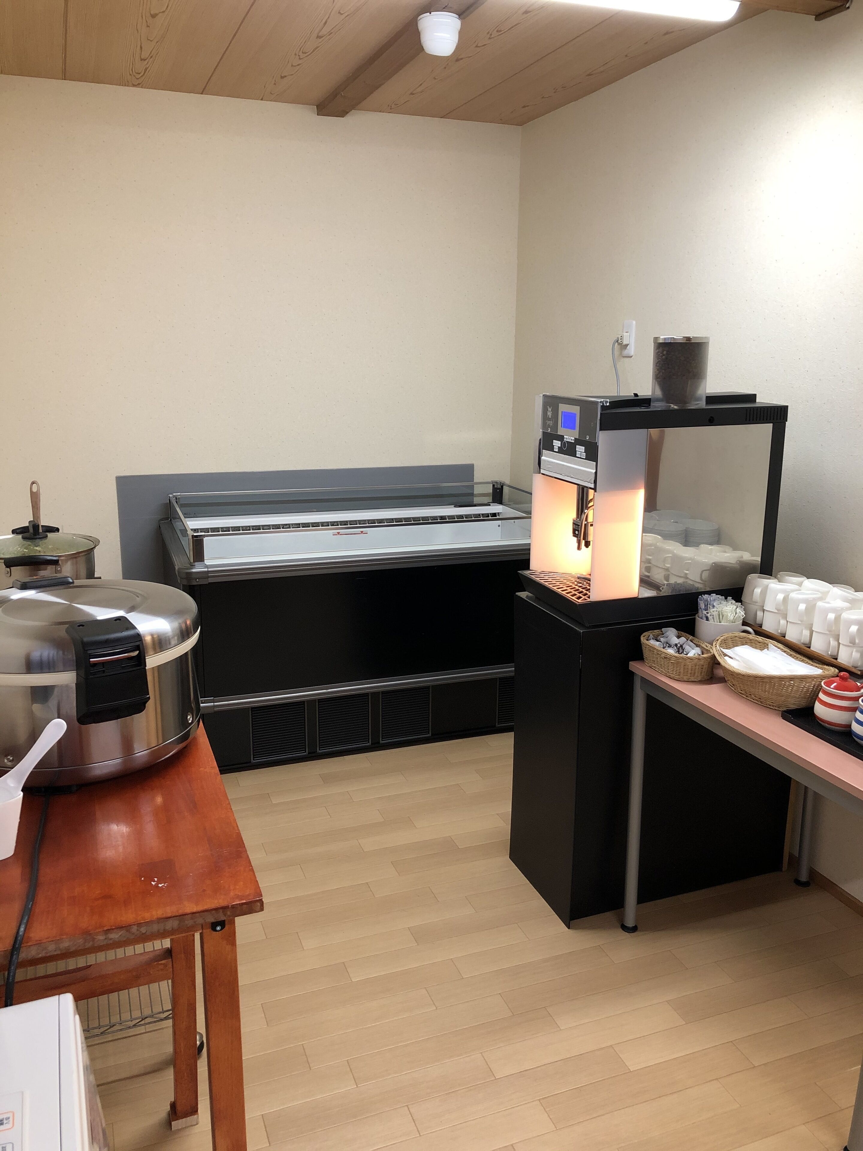 A kitchen area with a large industrial oven, a coffee machine, and a buffet setup with plates and utensils.