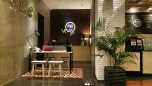 Un interior moderno con una cafetera, una laptop sobre un escritorio y un letrero que dice 'POD'.